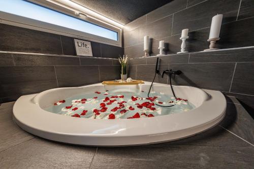 un bagno con vasca piena di cuori di Visionary Hospitality - Big Premium Loft with View, Washer, Parking, Kitchen, Tub a Dierikon