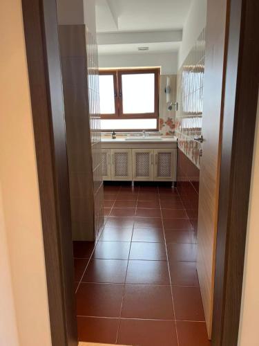 ein Bad mit Fliesenboden und einem Fenster in der Unterkunft Apartament Pogradeci in Pogradec