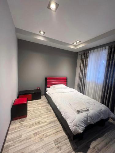 Schlafzimmer mit einem großen Bett mit einem roten Kopfteil in der Unterkunft Apartament Pogradeci in Pogradec