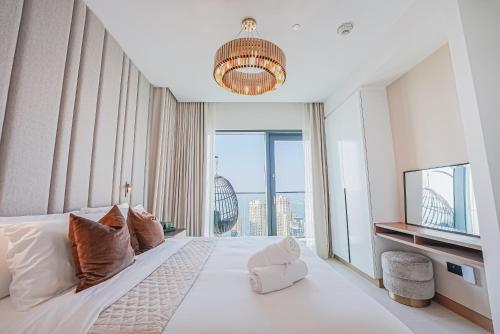 um quarto com uma cama grande e uma janela grande em Modern 2BR High Floor Haven in Vida Dubai Marina em Dubai