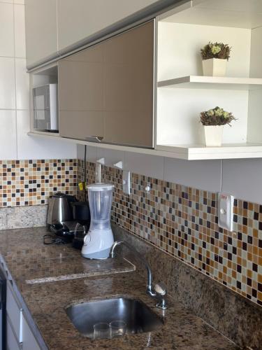 eine Küchentheke mit einer Spüle und einem Mixer in der Unterkunft Surpreenda-se excelente apartamento com vista mar in Salvador