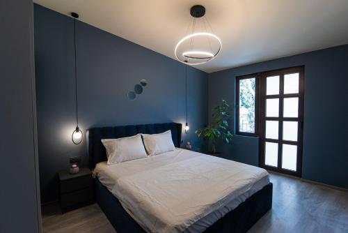 a bedroom with a large bed with blue walls at Nice and cosy villa in the heart of the city in Tbilisi City