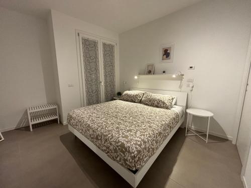 - une chambre blanche avec un lit et une table dans l'établissement SUITE NAVIGLIO 26, à Parme