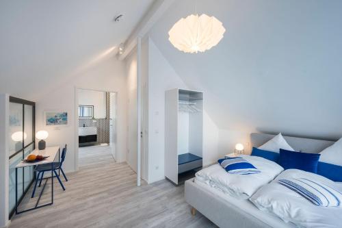 een slaapkamer met een groot bed met blauwe kussens bij living TIMELESS- Design Apartment Bodensee- Friedrichshafen in Friedrichshafen