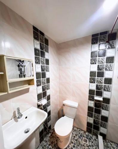 een badkamer met een wit toilet en een wastafel bij Cozy Loft Near the Airport & Beach-Unit I in Puerto Princesa City