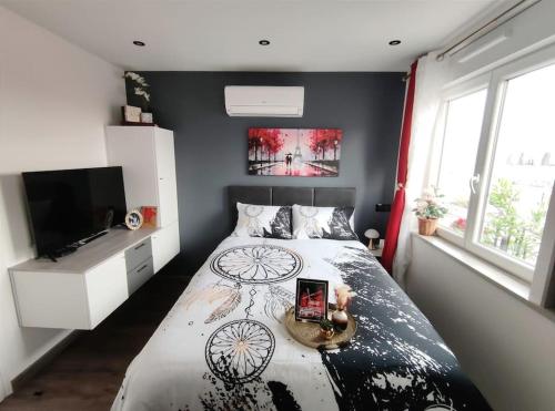 um quarto com uma cama e uma televisão de ecrã plano em Your hidden charm by Paris em Le Kremlin-Bicêtre