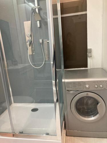 a washing machine in a bathroom with a shower at AV. CHAMPS ELYSEES 78 in Paris
