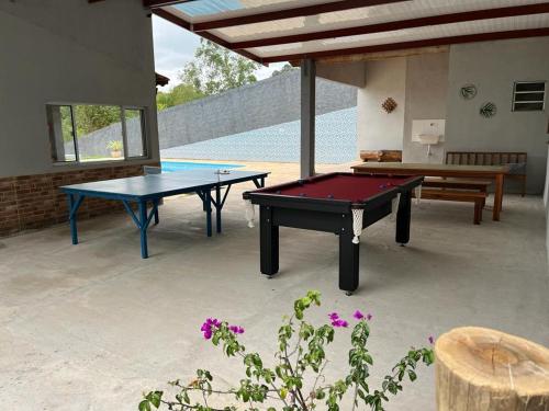 un patio con 2 mesas de ping pong y un banco en Chácara em Alpes de Mairiporã, en Mairiporã