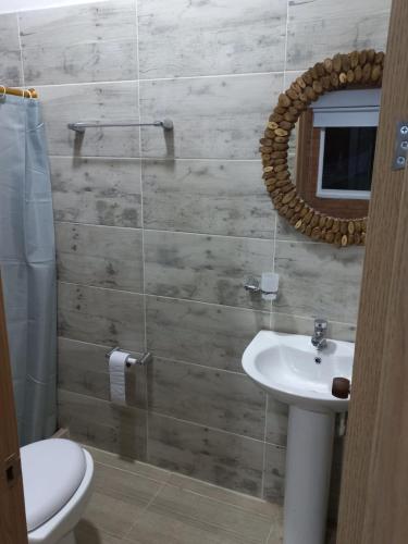 ein Badezimmer mit Waschbecken, Toilette und Spiegel in der Unterkunft FINCA VILLA BLANCA in Termales