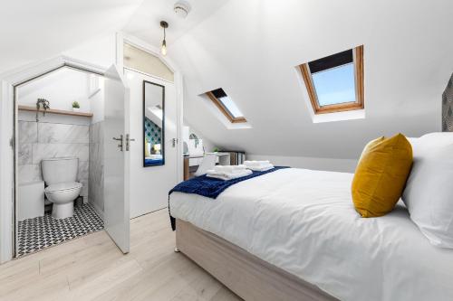 um quarto com uma cama e uma casa de banho com um WC em The Holloway Suite - 1BR Modern Apartment em Londres