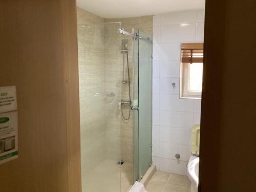 y baño con ducha y aseo. en Adis Hotels Ibadan en Ibadán