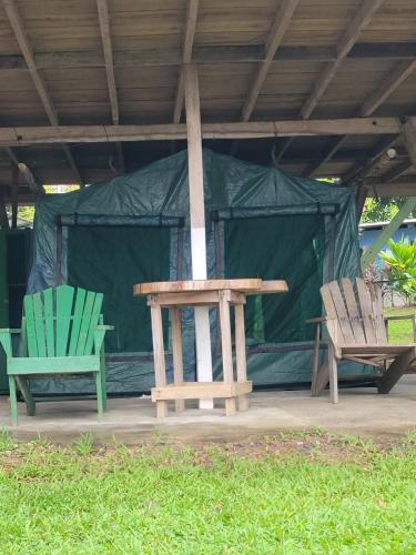 two chairs and a table in front of a tent at Life for Life Hostel Drake Bay Home of Sea Turtle Marine Conservation Project Osa Peninsula near San Josecito Beach in Drake
