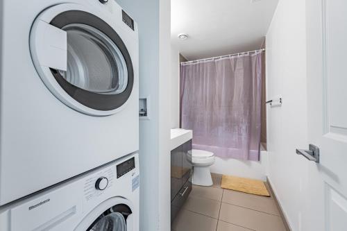 a bathroom with a washing machine and a toilet at Luxury Properties in Toronto Downtown Core in Toronto