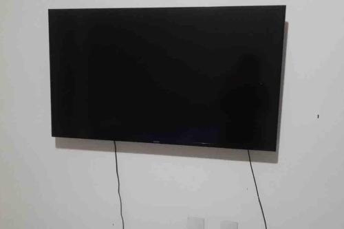 a flat screen tv on a white wall at Casa da Cascata de Crato in Crato