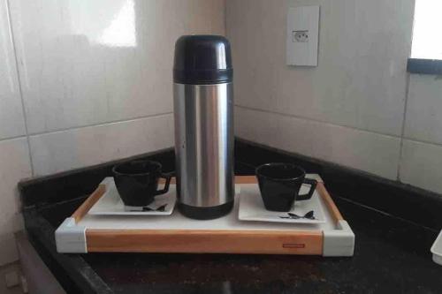 a coffee machine sitting on a counter with two cups at Casa da Cascata de Crato in Crato