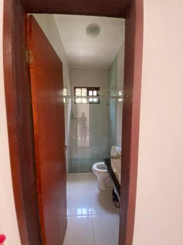 a bathroom with a toilet and a glass shower at Casa da Cascata de Crato in Crato