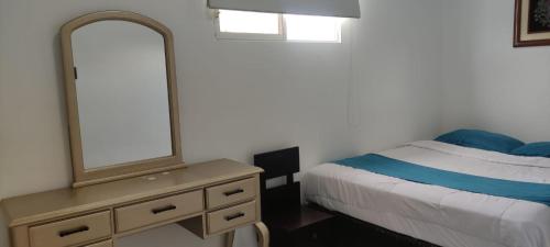 a bedroom with a bed and a dresser with a mirror at Hotel Mykonos Manta in Manta