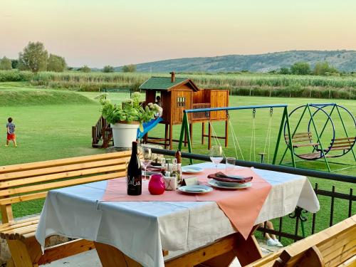 a table with a bottle of wine and a playground at Shasi Eco Lodge in Ambula