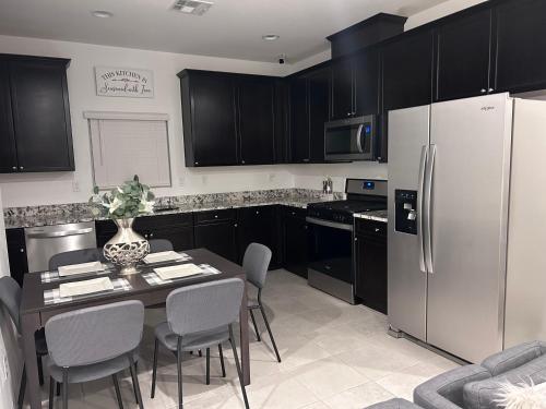 y cocina con mesa, sillas y nevera. en New, and Modern Home close to the strip en Las Vegas