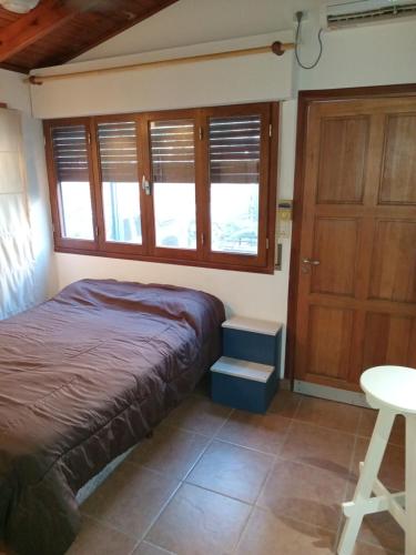 1 dormitorio con cama, mesa y puerta en (El departamento) en Pergamino