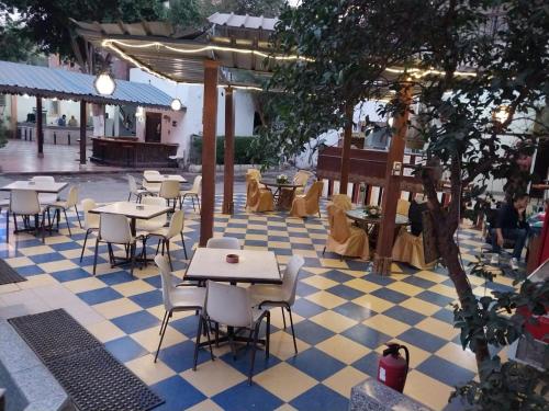a restaurant with tables and chairs on a checkered floor at Rezeiky Hotel & Camp in Luxor