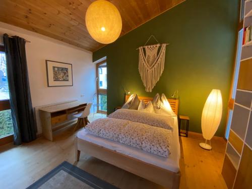 a bedroom with a bed with a green wall at Ferienhaus in Westendorf in Westendorf