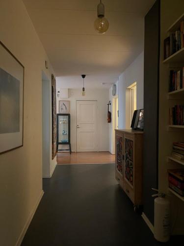 um corredor com uma porta branca e um quarto com uma prateleira em Stor lägenhet - 150 meter från havet. em Helsingborg