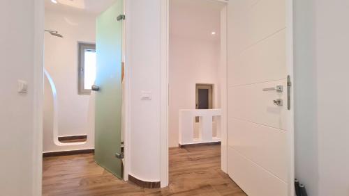 a hallway with white walls and wooden floors at VILLA PANAMERA Mykonos, Private Heaven, Supreme View! in Fanari