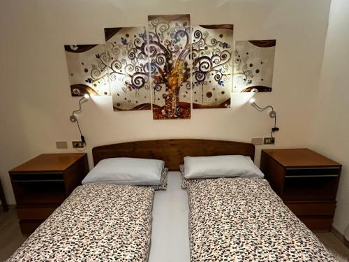 sypialnia z 2 łóżkami i obrazem na ścianie w obiekcie My Dolomites Home w mieście Livinallongo del Col di Lana
