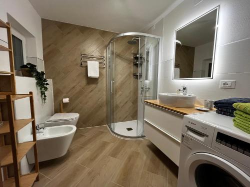 uma casa de banho com um chuveiro, um WC e um lavatório. em My Dolomites Home em Livinallongo del Col di Lana