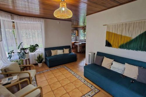 a living room with a blue couch and a table at Casa Roble Fortuna in Fortuna