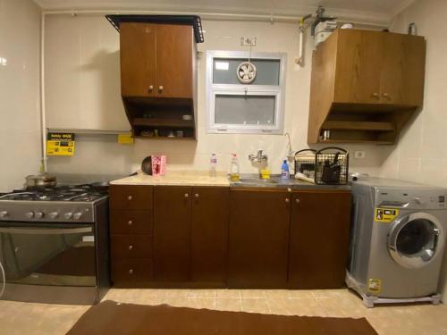 eine Küche mit einem Herd und einer Waschmaschine in der Unterkunft Lovely 3 Bedrooms Apartment in Madinaty