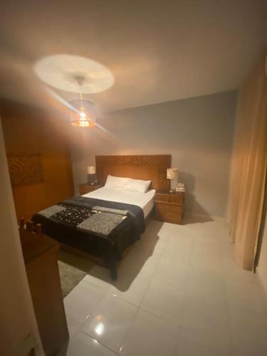 a bedroom with a bed and a light on the ceiling at Lovely 3 Bedrooms Apartment in Madinaty