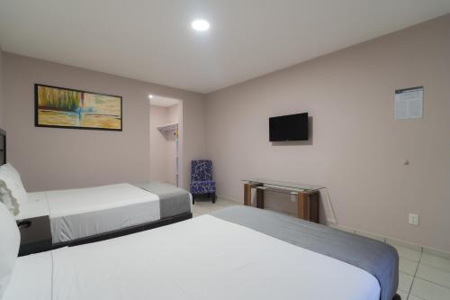 um quarto de hotel com duas camas e uma televisão em Expo Hotel Guadalajara - Zona Expo frente al Centro de Convenciones em Guadalajara