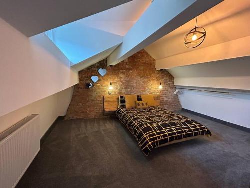 um quarto com uma cama e uma parede de tijolos em Cottage in Holmfirth Centre em Holmfirth