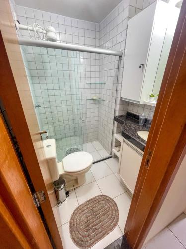 a bathroom with a toilet and a glass shower at Flat Condomínio Monte Castelo Gravatá in Bezerros