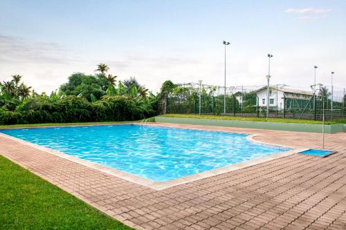 - une piscine d'eau bleue dans la cour dans l'établissement Le Privilège appartement standing, piscine, terrasse, jardin, parking privé, à Cayenne