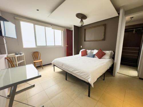 um quarto com uma cama e uma mesa em Loft 2 cuartos Terraza y baño privados em Cidade do México