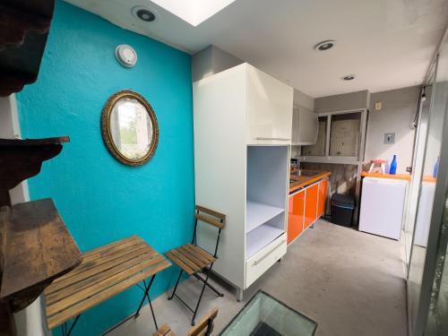 uma cozinha com uma mesa e uma parede azul em Loft 2 cuartos Terraza y baño privados em Cidade do México