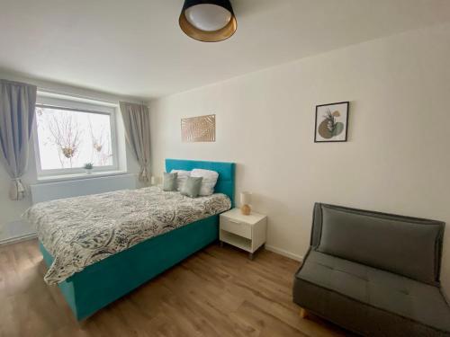 1 dormitorio con 1 cama y 1 silla en Apartmány Mýtinka - Jeseníky, en Jeseník