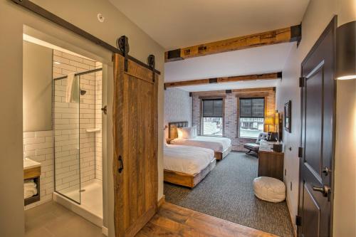 a bedroom with a bed and a bathroom with a shower at Hotel Crosby in Stillwater