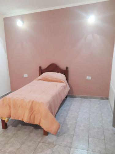 a bedroom with a bed and two lights on the wall at La estadía in La Banda