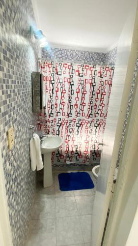 a bathroom with a red and white shower curtain at La estadía in La Banda