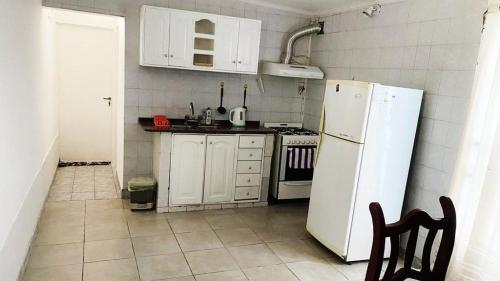 a kitchen with white cabinets and a white refrigerator at La estadía in La Banda
