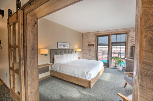 a bedroom with a bed and a large window at Hotel Crosby in Stillwater