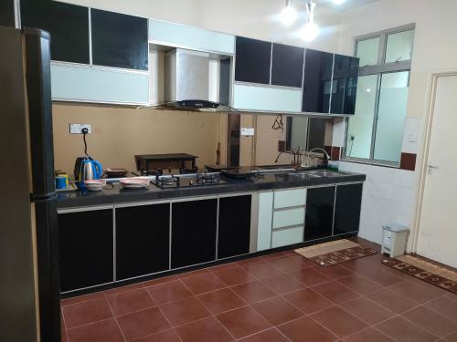 eine Küche mit schwarzen und weißen Schränken und einer Theke in der Unterkunft Homestay Cheng No14 Double Storey, 4 Bedroom in Malakka