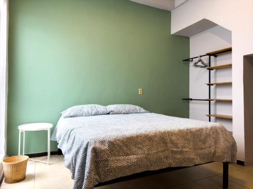 um quarto com uma cama e uma parede verde em Cuarto 2 - Roma Norte Cama Queen Size em Cidade do México