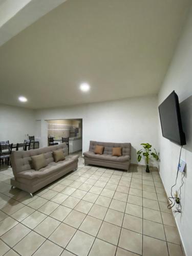 a living room with two couches and a flat screen tv at Depa en el centro de Calvillo B in Calvillo