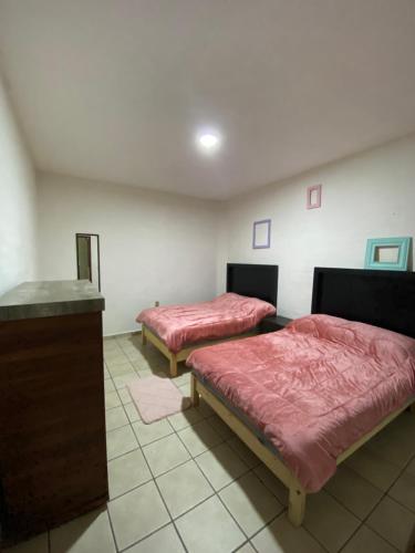 a room with two beds and a counter in it at Depa en el centro de Calvillo B in Calvillo