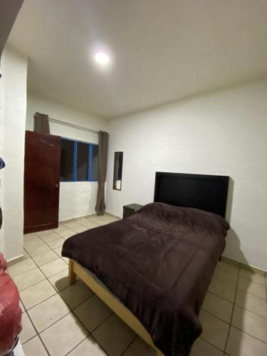 a bedroom with a bed with a brown blanket at Depa en el centro de Calvillo B in Calvillo